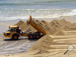 A load of sand is dumped on the beach in front of the Ocean Casino Resort in Atlantic City, N.J., Friday, May 12, 2023. The casino is spending up to $700,000 of its own money to rebuild the eroded beach, deciding it cannot wait another year or two for the next government-funded beach widening project scheduled for the area. (AP Photo/Wayne Parry)