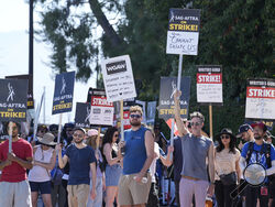 FILE - Actors and writers demonstrate on a picket line outside Disney studios on Tuesday, July 18, 2023, in Burbank, Calif. A world of hair, makeup and manicurists have been idled by the Hollywood strikes at a time when they were still rebuilding from the covid shutdowns. (AP Photo/Chris Pizzello)