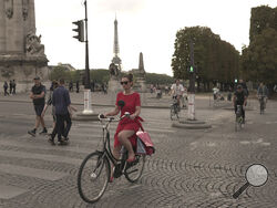 A woman rides on the Alexandre III bridge in Paris, Wednesday, Sept. 13, 2023. Years of efforts to turn car-congested Paris into a more bike-friendly city are paying off ahead of the 2024 Olympics, with increasing numbers of people using the French capital's growing network of cycle lanes. (AP Photo/John Leicester)