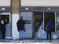 People view a ransacked liquor store in Philadelphia, Wednesday, Sept. 27, 2023. Police say groups of teenagers swarmed into stores across Philadelphia in an apparently coordinated effort, stuffed bags with merchandise and fled. (AP Photo/Matt Rourke)