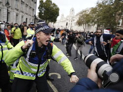 Police Officers clash with rival supporters as protesters walk past the Cenotaph on Whitehall during a pro-Palestine march organized by Palestine Solidarity Campaign in central London, Saturday, Oct. 28, 2023. (Jordan Pettitt/PA via AP)