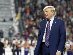  Republican presidential candidate and former President Donald Trump stands on the field during halftime in an NCAA college football game between the University of South Carolina and Clemson Saturday, Nov. 25, 2023, in Columbia, S.C. (AP Photo/Meg Kinnard)