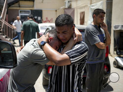 Palestinians mourn relatives killed in the Israeli bombardment of the Gaza Strip, at a hospital morgue in Deir al-Balah, Tuesday, July 9, 2024. (AP Photo/Abdel Kareem Hana)