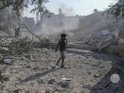 AP Photo/Abdel Kareem Hana A Palestinian boy walks past the rubble of a school destroyed in an Israeli airstrike on Deir al-Balah, central Gaza Strip, Saturday.