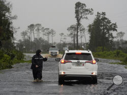 A man walks through storm surge on the flooded road into Horseshoe Beach, Fla., Monday morning, Aug. 5, 2024. Hurricane Debby made landfall early this morning. (AP Photo/Christopher O'Meara)