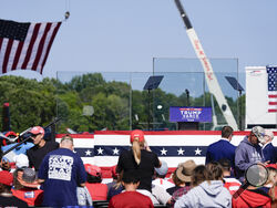 An outdoor stage is set encased with bulletproof glass as supporters arrive to hear Republican presidential nominee former President Donald Trump speak at a rally, Wednesday, Aug. 21, 2024, in Asheboro, N.C. Trump is holding his first outdoor rally since narrowly surviving an attempted assassination when a a gunman opened fire in Pennsylvania last month. (AP Photo/Julia Nikhinson)