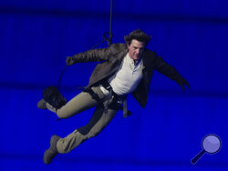 Tom Cruise is lowered on the Stade de France during the 2024 Summer Olympics closing ceremony, Sunday, Aug. 11, 2024, in Saint-Denis, France. (AP Photo/Natacha Pisarenko)