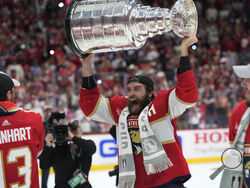 Florida Panthers defenseman Aaron Ekblad raises the NHL hockey Stanley Cup trophy after defeating the Edmonton Oilers in Game 7 of the Final, Monday, June 24, 2024, in Sunrise, Fla. (AP Photo/Wilfredo Lee)