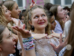 Swifties gather and sing in the city centre in Vienna on Thursday, Aug.8, 2024. Organizers of three Taylor Swift concerts in the stadium in Vienna this week called them off on Wednesday after officials announced arrests over an apparent plot to launch an attack on an event in the Vienna area such as the concerts. (AP Photo/Heinz-Peter Bader)