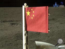 In this China National Space Administration (CNSA) handout image released by Xinhua News Agency, a Chinese national flag carried by the lander of Chang'e-6 probe unfurls at the moon's far side, Tuesday, June 4, 2024. China says a spacecraft carrying rock and soil samples from the far side of the moon has lifted off from the lunar surface to start its journey back to Earth. (CNSA/Xinhua via AP)