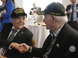 World War II veterans Andy Negra, left, and Hilbert Margol, speak to each other during an an event honoring the two on Thursday, March 14, 2024, in Atlanta. Margol is a 100-year-old World War II veteran living in Dunwoody, Ga. He and his twin brother, Howard Margol, were a part of the 42nd Infantry that arrived in Marseille, France, in January 1945. (AP Photo/Brynn Anderson)