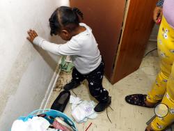 In this Feb. 20, 2019 photo, Destiny Johnson's son, Hayden Howard, 2, steps on roaches in his mother's apartment in Cedarhurst Homes, a federally subsidized, low-income apartment complex in Natchez, Miss. The complex failed a health and safety inspection in each of the past three years. Upset with conditions, Johnson moved out in late March. (AP Photo/Rogelio V. Solis)