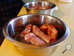 This Feb. 21, 2019, photo shows turkey necks and gizzards that are being served to Gracie and Takaani, two German shepherds who live in Oconomowoc, Wis., with their owners Deb and Joe Colgan. The Colgans started feeding their two previous dogs raw meat seven years ago and continued with Gracie and Takaani because they say they are healthier and have cleaner teeth. U.S. pet owners are increasingly feeding raw, freeze dried or lightly cooked meat and vegetables to their dogs and cats. (AP Photo/Carrie Antlfin
