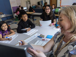 Fifth grade students attend a math lesson with teacher Jana Lamontagne, right, during class at Mount Vernon Community School, in Alexandria, Va., Wednesday, May 1, 2024. (AP Photo/Jacquelyn Martin)