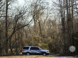 A police vehicle is parked on a road leading to the scene of a helicopter crash in Washington Township, N.J., Wednesday, Dec. 20, 2023. Investigators are examining the wreckage of a TV news helicopter that crashed in the New Jersey Pinelands, killing the pilot and a photographer on board. WPVI-TV of Philadelphia says a two members of its news team were in the helicopter when it went down about 8 p.m. Tuesday in Wharton State Forest. (AP Photo/Matt Rourke)
