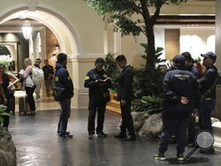 Police gather outside the Grand Hyatt Erawan Hotel in Bangkok, Thailand, Tuesday, July 16, 2024. Police said a number of people were found dead Tuesday in the luxury hotel in downtown Bangkok and poisoning is suspected. (AP Photo/Chatkla Samnaingjam)