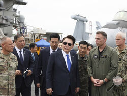 FILE - South Korean President Yoon Suk Yeol, center, boards the USS Theodore Roosevelt aircraft carrier at the South Korean naval base in Busan, South Korea, Tuesday, June 25, 2024. The newly-inaugurated Freedom Edge exercise is wrapping up in the East China Sea, having brought together Japanese, South Korean and American naval assets for multi-domain maneuvers for the first time. (South Korean Presidential Office/Yonhap via AP, File)