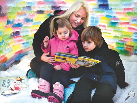 With a fleece rug spread on the ground inside the Attanasio family igloo, Brianna reads a story to Briella and Ethan on Saturday evening. The family built an igloo at their Elysburg-area home using ice blocks made from loaf pans, water and paint.