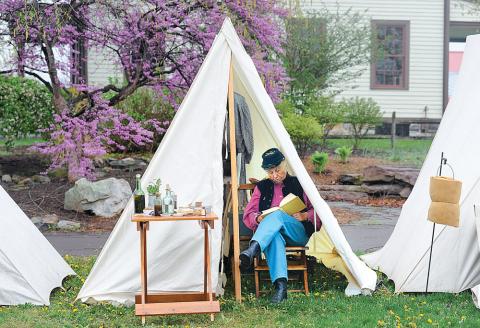 Susan Sprout, Picture Rocks, catches up on some reading after finding cover from a rain shower Friday morning at the History Comes Alive encampment at the Bloomsburg fairgrounds Friday morning. Sprout talked about plants and herbs that were used in the time of the Civil War. The History Comes Alive event runs today and Sunday and is open to the public free of charge.