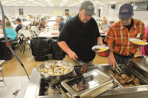 Steven Sitler, left, treats his father Rick Sitler to breakfast Sunday morning at the Espy Fire Hall for the department's fundraiser on Father's Day. 