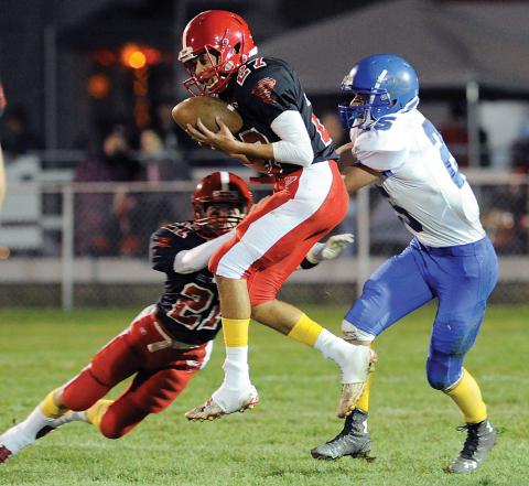 Mount Carmel’s Treyvon White, center, pulls in an interception intended for Warrior Run’s William Michael, right, as Mount Carmel’s Lane Tanney also dives into the play during the first quarter of Friday night’s game in Mount Carmel. 