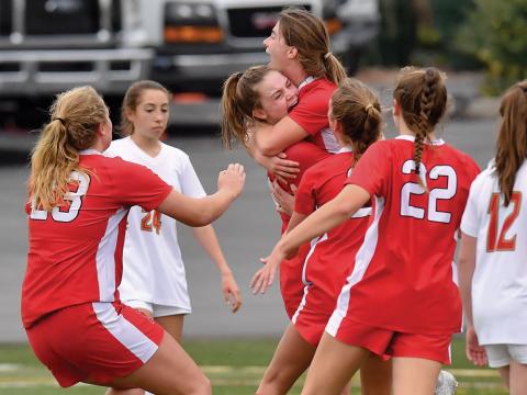 Bloomsburg’s Rylee Klinger, center left, lifts up Paige Temple, while Madeline Evans, left, Brynna Zentner, center and Maizy Aikey, second from the right, run in after Temple scored the only goal of the game on a penalty kick in the second half of the PIAA Class 2A soccer championships against North Catholic at Hersheypark Stadium Saturday.