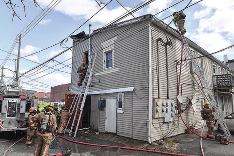 Danville firefighters battle an apartment fire Friday along Rooney Avenue. The building front is at 479 Mill St.