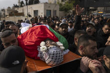 Palestinian mourners carry the body of Hazem Qatawi, 23, headband reads "al-Aqsa Martyrs brigades," during his funeral in the West Bank city of Beitunia, Thursday, Dec. 28, 2023. Palestinian health ministry said that Qatawi was killed during an Israeli army raid in Ramallah early morning. (AP Photo/Nasser Nasser)