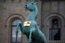 A golden Leibniz cookie hangs from a horse's neck in front of the Leibniz University in Hannover, Germany, Tuesday.