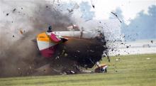 A stunt plane crashes during a wing walker's performance at the Vectren Air Show, Saturday, June 22, 2013, in Dayton, Ohio. The crash killed the pilot and the wing walker instantly, authorities said. (AP Photo/Thanh V Tran) 