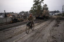 Oleksandr, 81, rides a bicycle next to a destroyed Russian tank in the outskirts of Kyiv, Ukraine, Thursday, March 31, 2022. Russian forces shelled Kyiv suburbs, two days after the Kremlin announced it would significantly scale back operations near both the capital and the northern city of Chernihiv to “increase mutual trust and create conditions for further negotiations.” (AP Photo/Rodrigo Abd)