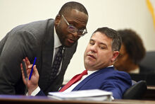 Sen. Shevrin Jones, D-West Park, left, confers with Sen. Travis Hutson, R-St. Augustine, right, during the Committee on Fiscal Policy meeting Monday, Dec. 12, 2022, at the Capitol in Tallahassee, Fla. Florida lawmakers are meeting to consider ways to shore up the state's struggling home insurance market in the year's second special session devoted to the topic. (AP Photo/Phil Sears)