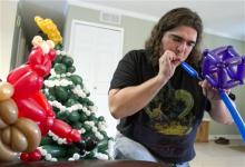 n this Nov. 12, 2012, photo, Tim Thurmond, works on a sculpture of Christmas-themed balloons in Brighton, Mich. (AP Photo/Livingston County Daily Press & Argus, Gillis Benedict) 