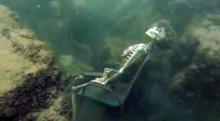 In this frame from video provided by the La Paz Sheriffs' Office, fake skeletons are strategically placed to appear as if they were sitting together with their lawn chairs bound to large rocks in the Colorado River near the Arizona and California border.