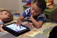 Frankie Thevenot, 3, plays with an iPad in his bedroom at his home in Metairie, La. As of Wednesday, Aug. 7, 2013, the Campaign for a Commercial-Free Childhood is urging federal investigators to examine the marketing practices of Fisher-Price's and Open Solution's mobile apps. It's the campaign's first complaint against the mobile app industry as part of its broader push to hold accountable businesses that market technology to very young children and their parents. (AP Photo/Gerald Herbert, File)