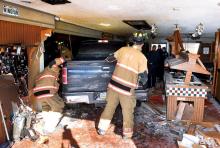 Bloomsburg firefighters work to get to the driver of a pickup truck that crashed through the wall of Pizza Hut and into the dining area Thursday afternoon. (Press Enterprise/Keith Haupt)