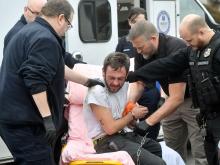 Police officers and EMS workers work together to get Justin Lindsay on a litter while he is secured in a handcuff belt, after he fought with parole officers along First Avenue in Berwick Tuesday afternoon. (Press Enterprise/Jimmy May)