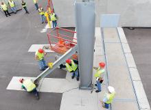 One of two main beams are placed into a hole in the road during a test of the flood barrier that protects the Autoneum plant near the Bloomsburg Fairgrounds Monday morning. (Press Enterprise/Keith Haupt)