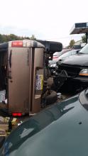 An SUV sits on its side against a pickup truck for sale at Trackside Auto Sales. Clifford Titus, 73, of Hetlerville, was critically injured when the vehicle flipped and dragged him early Monday morning. (Press Enterprise/Julye Wemple)