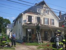 A firefighter climbs to the second floor of 1007 W. Front St. to help mop up a blaze that displaced 12 tenants, most of them children.