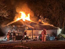 Press Enterprise/Susan Schwartz A bulldozer tears into Anne Dewald's burning house so water can reach the flames.