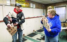 Press Enterprise/Rebecca Villagracia Instructor Cathy Curtin, right, gives a target sheet to Berwick High rifle team member Wyatt Readler at the Nescopeck Club site on Monday.