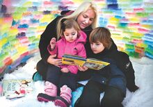 With a fleece rug spread on the ground inside the Attanasio family igloo, Brianna reads a story to Briella and Ethan on Saturday evening. The family built an igloo at their Elysburg-area home using ice blocks made from loaf pans, water and paint.