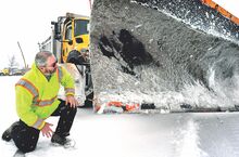 PennDOT equipment operator Ed Capper checks the blade on the snowplow before taking the truck out on Interstate 80 for plowing during the storm on Sunday afternoon.