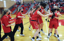 Members of the Mount Carmel girls basketball team celebrate together on the court after beating Southern Columbia for the district title Thursday night at Williamsport High School.