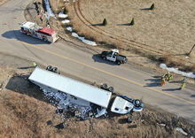 Emergency personnel stand next to a tractor trailer that rolled onto its side along Ringtown Mountain Road in Roaring Creek Township at its intersection with Old Reading Road Tuesday afternoon. 