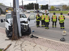 A van snapped off an utility pole along West Front Street at its intersection with Orange Street in Berwick on Thursday afternoon. In the background, firefighters direct traffic around three vehicles which were involved in a chain reaction crash on Orange Street because of the first crash. 