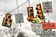 A worker with Tra Electric. Inc. of Watsontown repairs the mounts on temporary traffic lights at East Fort McClure Blvd and Ferry Road, near the Bloomsburg Airport on Friday. High winds broke the mounts on half the lights, leaving them hanging askew.