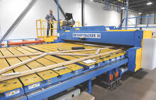 Supervisor Jeff Miller stands on a rolling press which moves across a truss attaching each gusset plate firmly to the truss on both sides. 