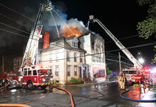 Ladder trucks from Danville and Bloomsburg battle flames from above the building that housed the Karen Gronsky School of Dance at 160 Center Street in Danville early Monday morning.